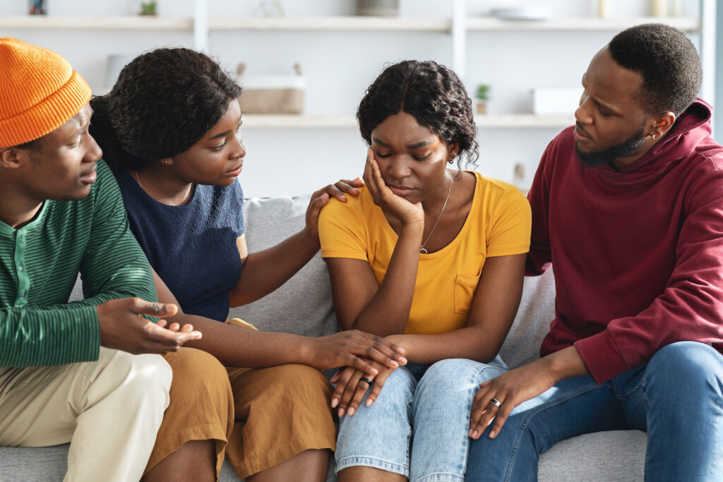 African american friends supporting upset young lady